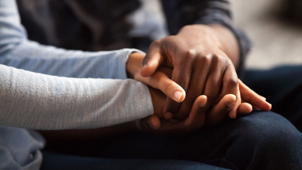 couple holding hands compassionately